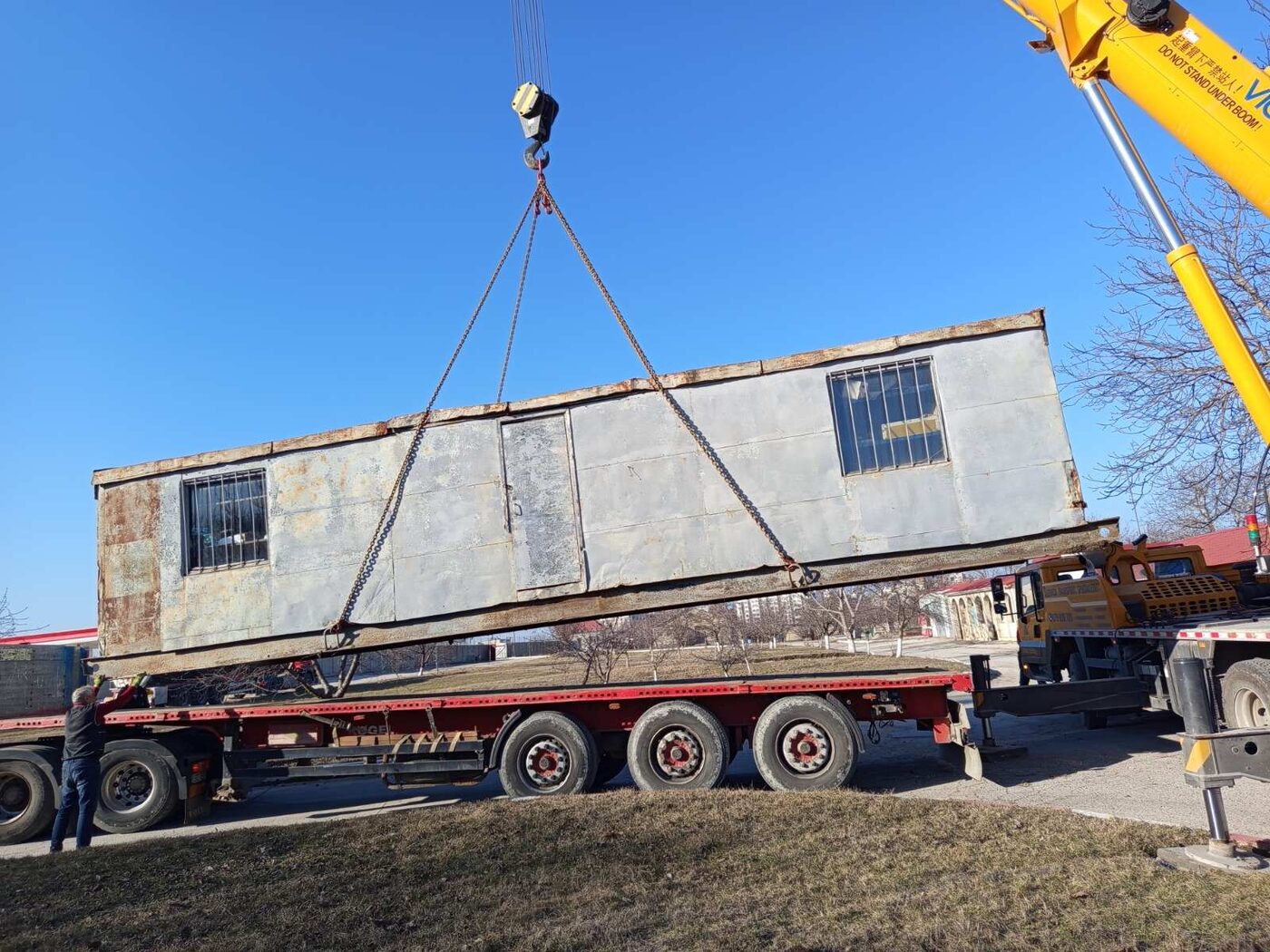 Macara-manipulator Auto Grițcan ridicând o cabină metalică mare pe trailer în Moldova