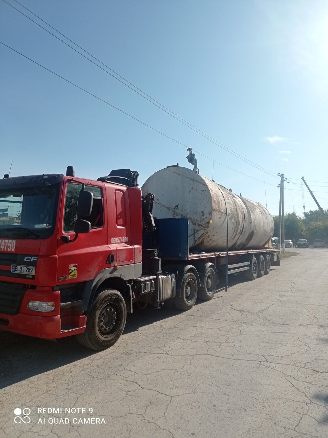 Cap tractor DAF roșu transportă o cisternă mare