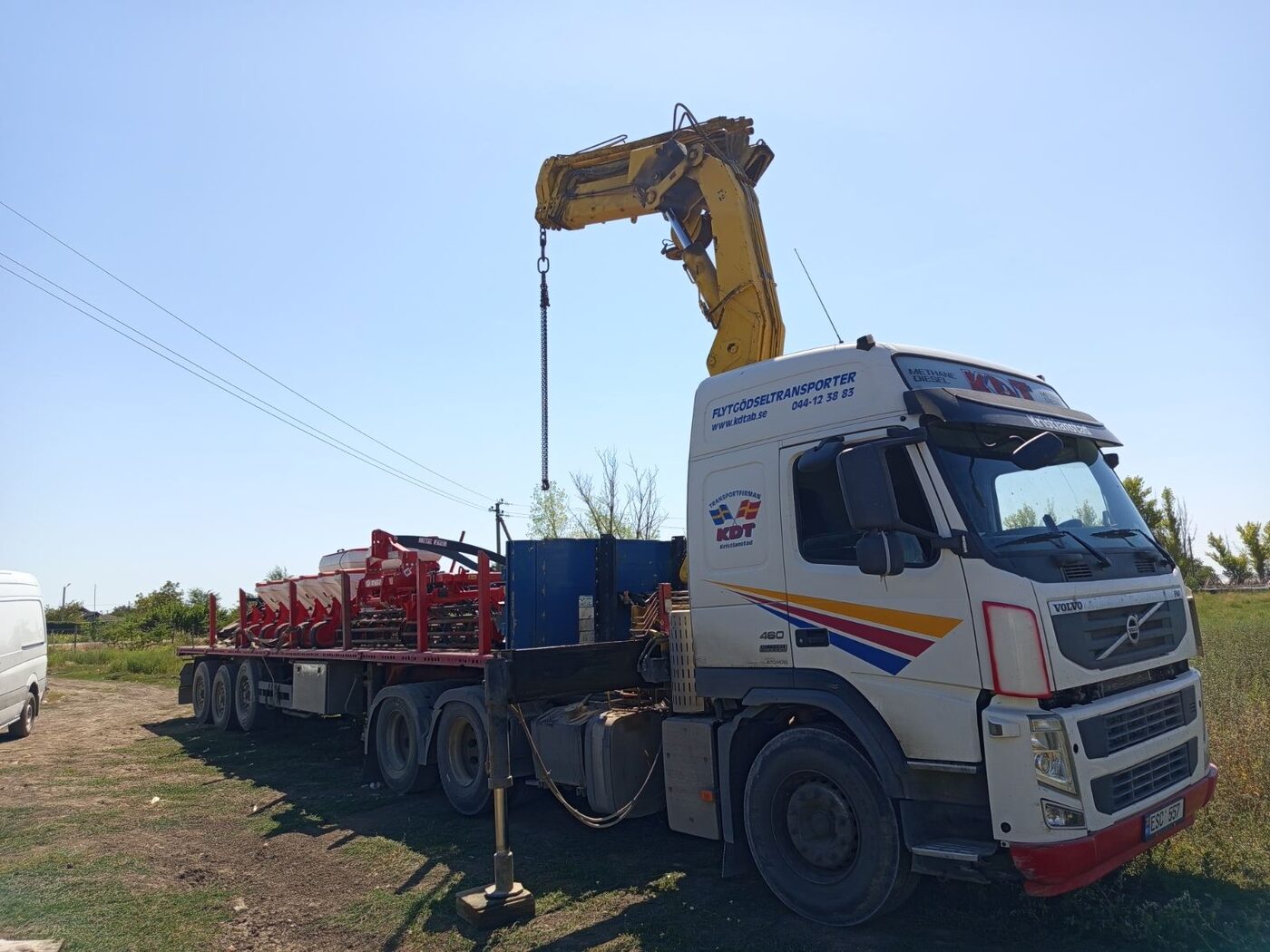 Camion cu macara și utilaj pe platformă